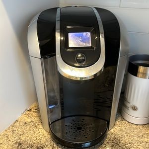 Keurig.  - used cleaned often-good condition. W/frother (no top) & some pods!